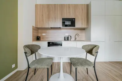a kitchen with a white table and four chairs at Blueground Letná furnished studio foodie area PRG-54 in Prague