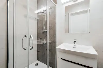 a white bathroom with a sink and a shower at Blueground Prague 7 renovated student housing PRG-59 in Prague