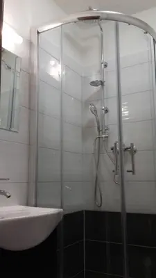 a shower with a glass door next to a sink at Penzion Staré Louny in Louny