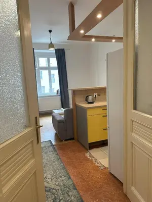 an open door to a kitchen with a chair and a table at Spacious place on Metro station Andel in Prague
