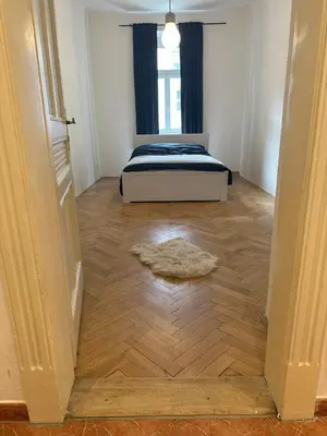 a bedroom with a bed and a wooden floor at Spacious place on Metro station Andel in Prague