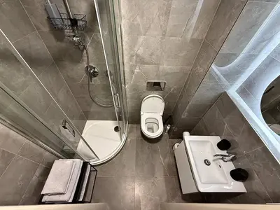 a bathroom with a shower and a toilet and a sink at NEW IOS Velour in Prague