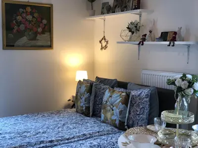 a table with a vase with a bouquet of flowers at Cozy Apartment Prague Airport- 5 minute drive from AirPort in Tuchoměřice