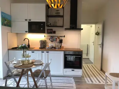 a cabinet with two bottles of alcohol and a pot at Cozy Apartment Prague Airport- 5 minute drive from AirPort in Tuchoměřice