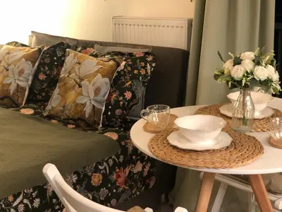 a bedroom with a bed and a table with plates and bowls at Cozy Apartment Prague Airport- 5 minute drive from AirPort in Tuchoměřice