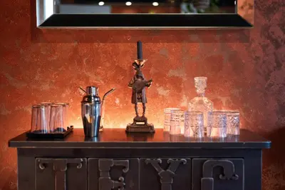 a table with glasses and a statue on top of it at Gentleman Spirit Residence Prague in Prague