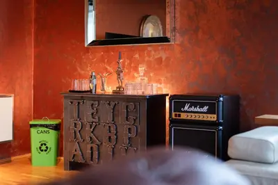 a living room with a stove and a red wall at Gentleman Spirit Residence Prague in Prague