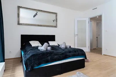 a bedroom with a black bed and a mirror on the wall at Brand Deluxe Suite in Prague