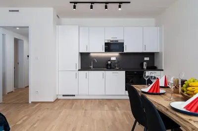 a kitchen with white cabinets and a wooden table at Brand Deluxe Suite in Prague
