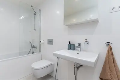 a white bathroom with a toilet and a sink at Brand Deluxe Suite in Prague