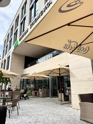 a building with tables and umbrellas in front of it at Downtown Prague in Prague