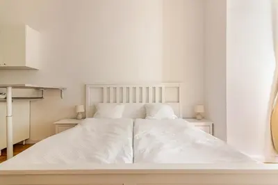 a white bed with white sheets and pillows at Beautiful Apartment by Stromovka Park in Prague