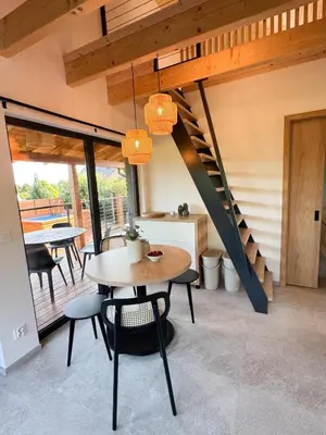 a dining room with a table and a staircase at Chalet Slapy in Slapy