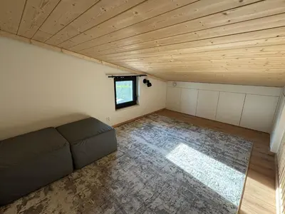a living room with a couch in a room with a wooden ceiling at Chalet Slapy in Slapy