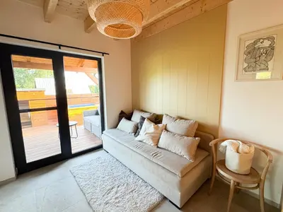 a living room with a couch and a sliding glass door at Chalet Slapy in Slapy
