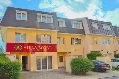 a large yellow building with a red sign on it at Royal Villas in Prague