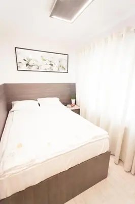a bedroom with a large bed with white sheets at Royal Villas in Prague