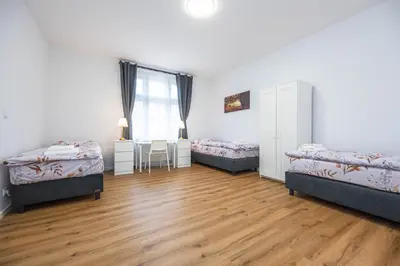 a room with three beds and a desk in it at Apartments Ripska in Prague
