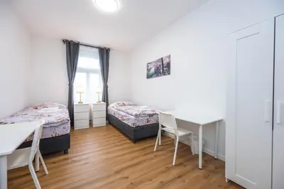a bedroom with a desk and a bed and a table at Apartments Ripska in Prague