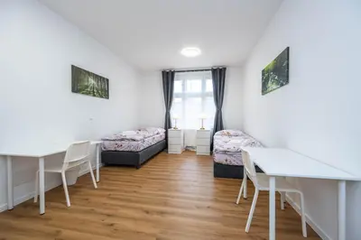 a room with two beds and a table and chairs at Apartments Ripska in Prague