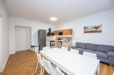 a kitchen and living room with a table and a couch at Apartments Ripska in Prague