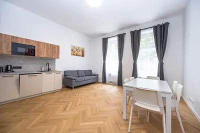 a kitchen and living room with a white table and chairs at Apartments Ripska in Prague