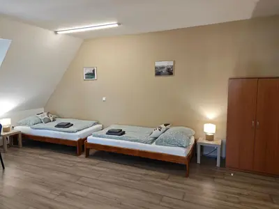 two twin beds in a room with two tables at Apartmány Zámecká in Roudnice nad Labem