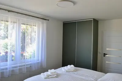 a bedroom with a bed with white sheets and a window at Newly renovated house near Prague in Nové Jirny