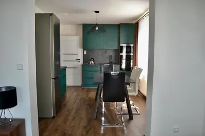 a kitchen with green cabinets and a table and chairs at Newly renovated house near Prague in Nové Jirny