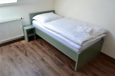 a bed in a small room with a wooden floor at Newly renovated house near Prague in Nové Jirny
