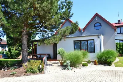 a white house with a tree in front of it at Newly renovated house near Prague in Nové Jirny