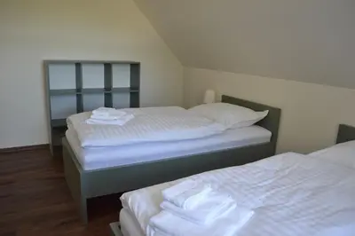 a bedroom with two beds with white sheets at Newly renovated house near Prague in Nové Jirny