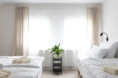 a white room with two beds and a tv on the wall at Hotel Sport Houštka