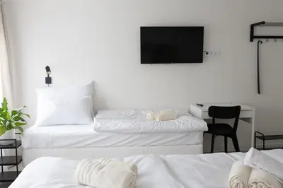 two beds in a room with a tv on the wall at Hotel Sport Houštka