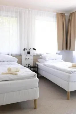 two white beds in a room with a window at Hotel Sport Houštka