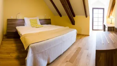 a bedroom with a large bed with yellow walls at Olivův Pivovar in Dolní Břežany