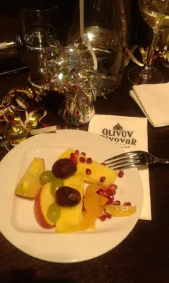 a white plate with fruit and nuts on a table at Olivův Pivovar in Dolní Břežany