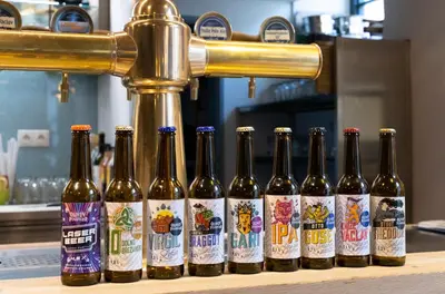 a row of bottles of beer sitting on a counter at Olivův Pivovar in Dolní Břežany