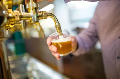 a man drinking beer from a beer tap at Olivův Pivovar in Dolní Břežany