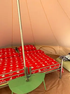 a red cover on a bed in a tent at Čerčanská Koupadla - glampingové stany in Benešov
