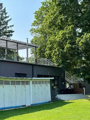 a house with a white fence and some trees at Čerčanská Koupadla - glampingové stany in Benešov