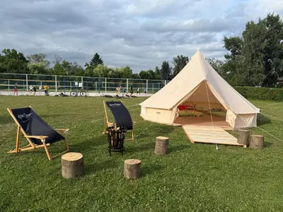 a tent and two chairs and a table and chairs at Čerčanská Koupadla - glampingové stany in Benešov