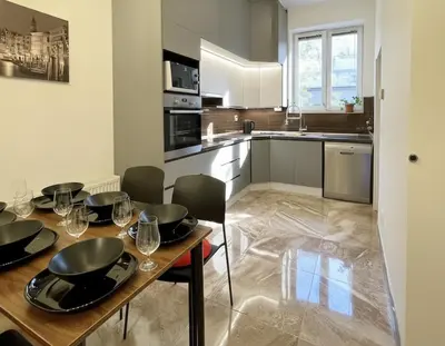 a kitchen with a wooden table with chairs and a dining room at City & River Apartment in Prague