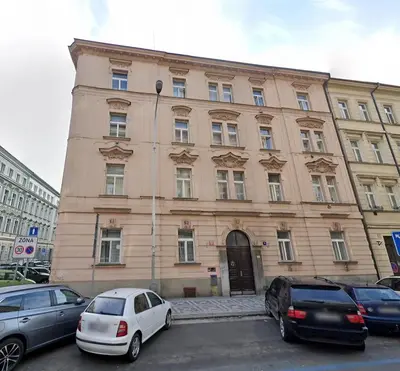 a large building with cars parked in front of it at City & River Apartment in Prague