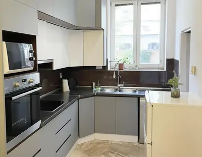 a kitchen with white cabinets and a sink and a microwave at City & River Apartment in Prague