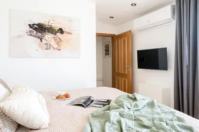 a bedroom with a bed with a book and a tv at Prague Days - Maisonette Retreat with Terrace, AC and TV Tower View in Prague