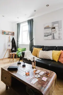 a living room with a black couch and a wooden coffee table at Prague Days - Maisonette Retreat with Terrace, AC and TV Tower View in Prague