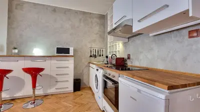a kitchen with white cabinets and red stools at Stylish Flat in Top Area ! New with Great Access in Prague