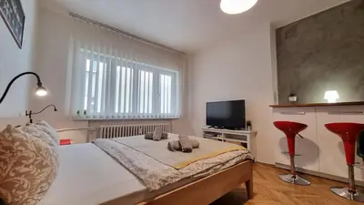 a bedroom with a large bed with two red chairs at Stylish Flat in Top Area ! New with Great Access in Prague
