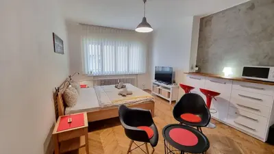 a room with a bed and chairs in it at Stylish Flat in Top Area ! New with Great Access in Prague